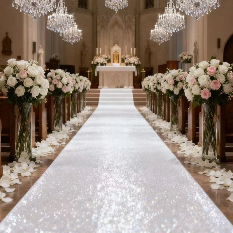 An elegant white sparkling aisle runner leading down a church aisle decorated with white flowers and chandeliers.