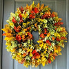 A vibrant artificial flower wreath featuring autumn colors like orange, yellow, and red leaves.