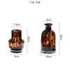 A dark amber glass vase with a leopard print pattern, shown from the side.