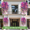 Quatre pièces de fleurs artificielles suspendues devant la façade d'une maison blanche.
