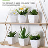 A display of six white artificial flowers in potted plants made of plastic foam, cloth, and iron wire.