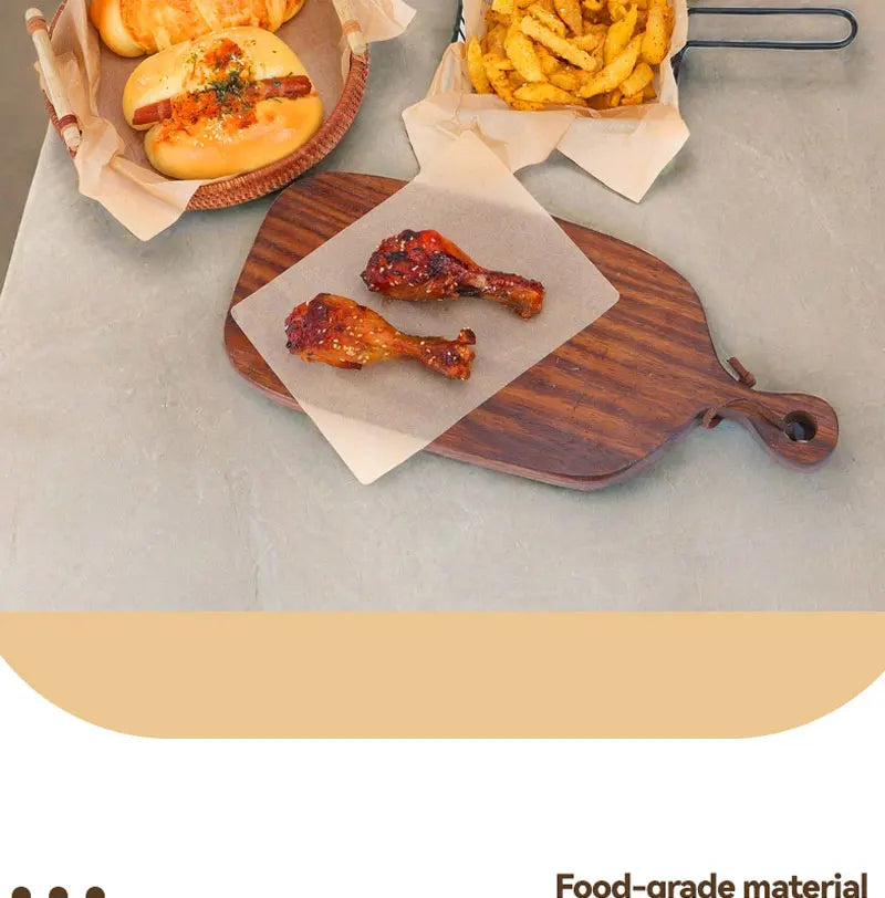 A wooden cutting board displays grilled chicken wings and a baked bun alongside a serving of french fries.