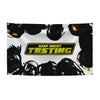 A black flag tapestry featuring a yellow banner with the text ASAP ROCKY TESTING and silhouettes of people.