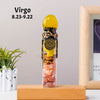 A glass bottle filled with raw healing stones and topped with a yellow crystal, representing Virgo zodiac sign.