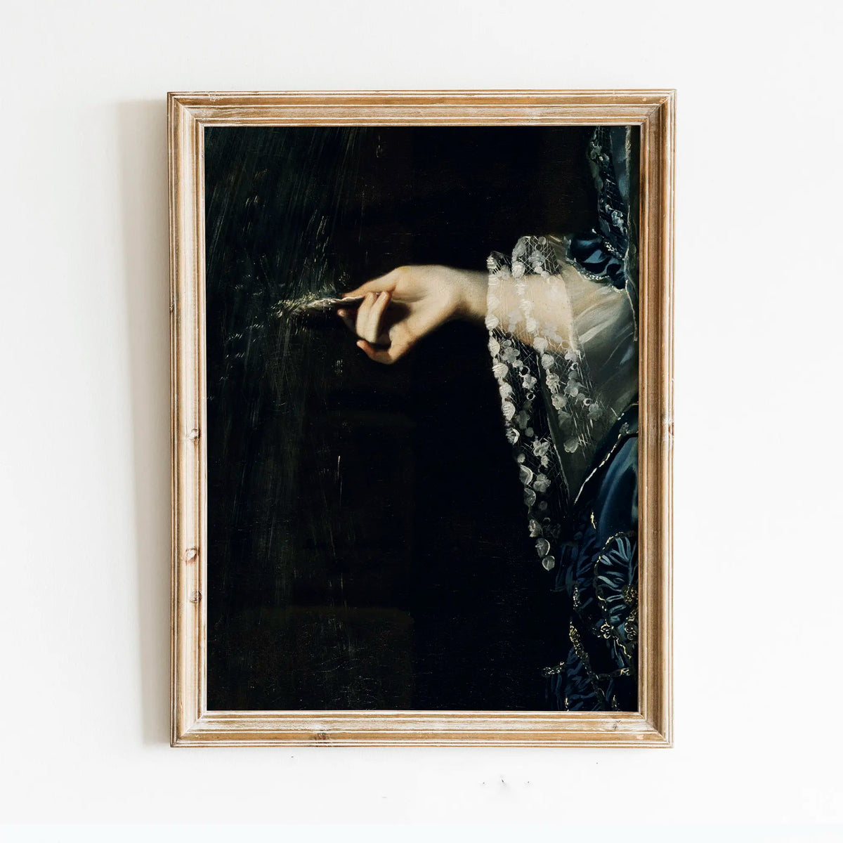 A framed dark academia vintage canvas print showing a hand delicately touching a dark surface with a lace-trimmed sleeve.