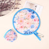 A blue fabric fan with a floral pattern is shown, along with a loose piece of the same fabric and a card.