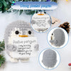 A gray and white crocheted penguin plush toy with an encouraging card, featuring text about positive penguins.