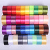A collection of rolled silk satin ribbons in various shades of pink, orange, green, purple, and blue.