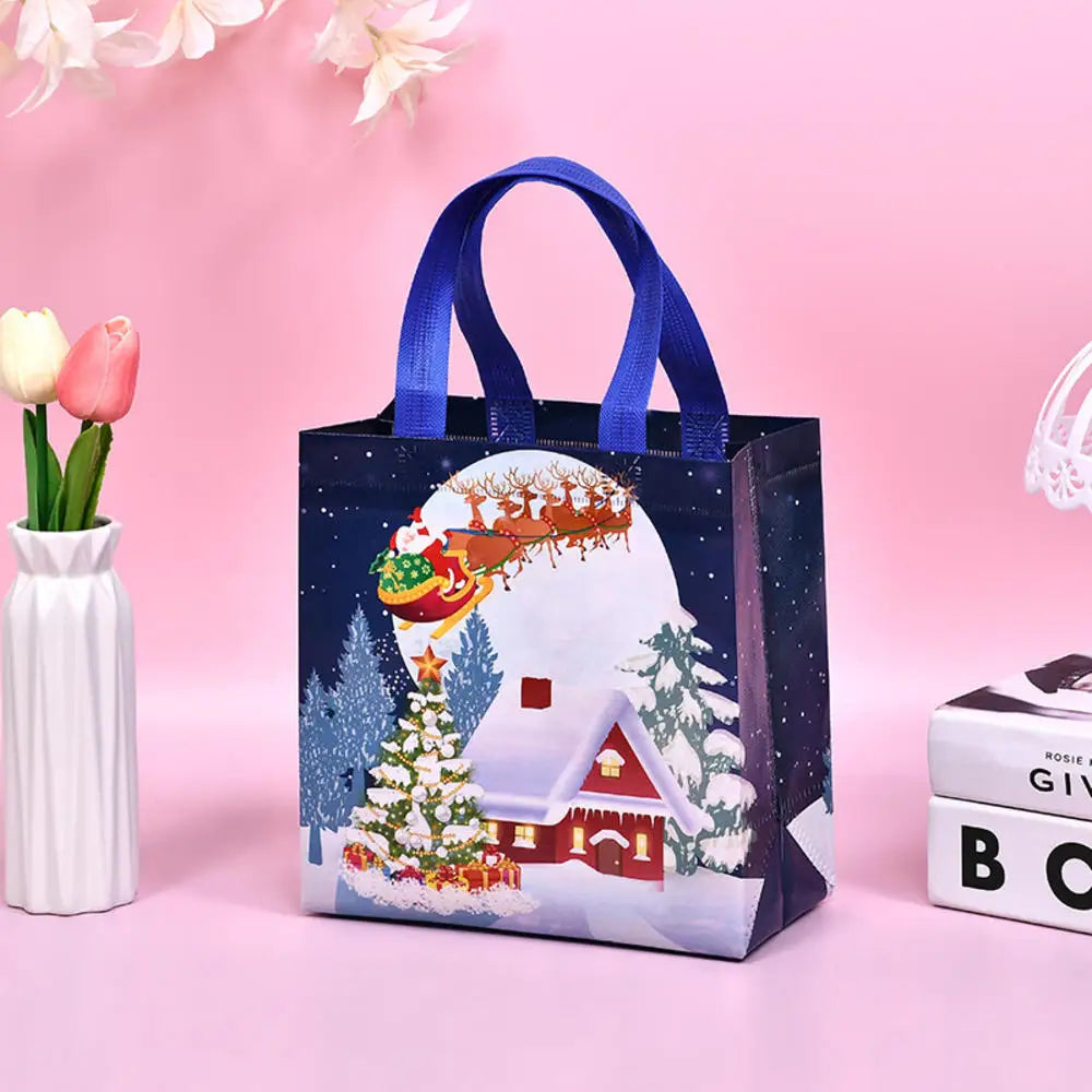 A dark blue non-woven tote bag featuring a festive Christmas print with a snowy scene and a house.