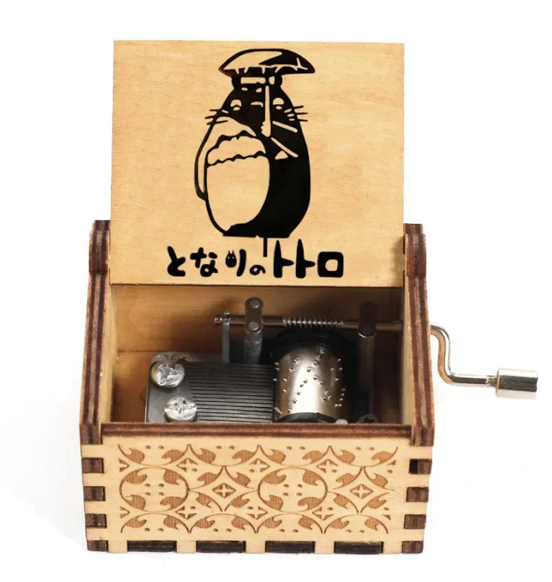A wooden music box featuring a silhouette of Totoro on the lid and a hand-cranked mechanism inside.