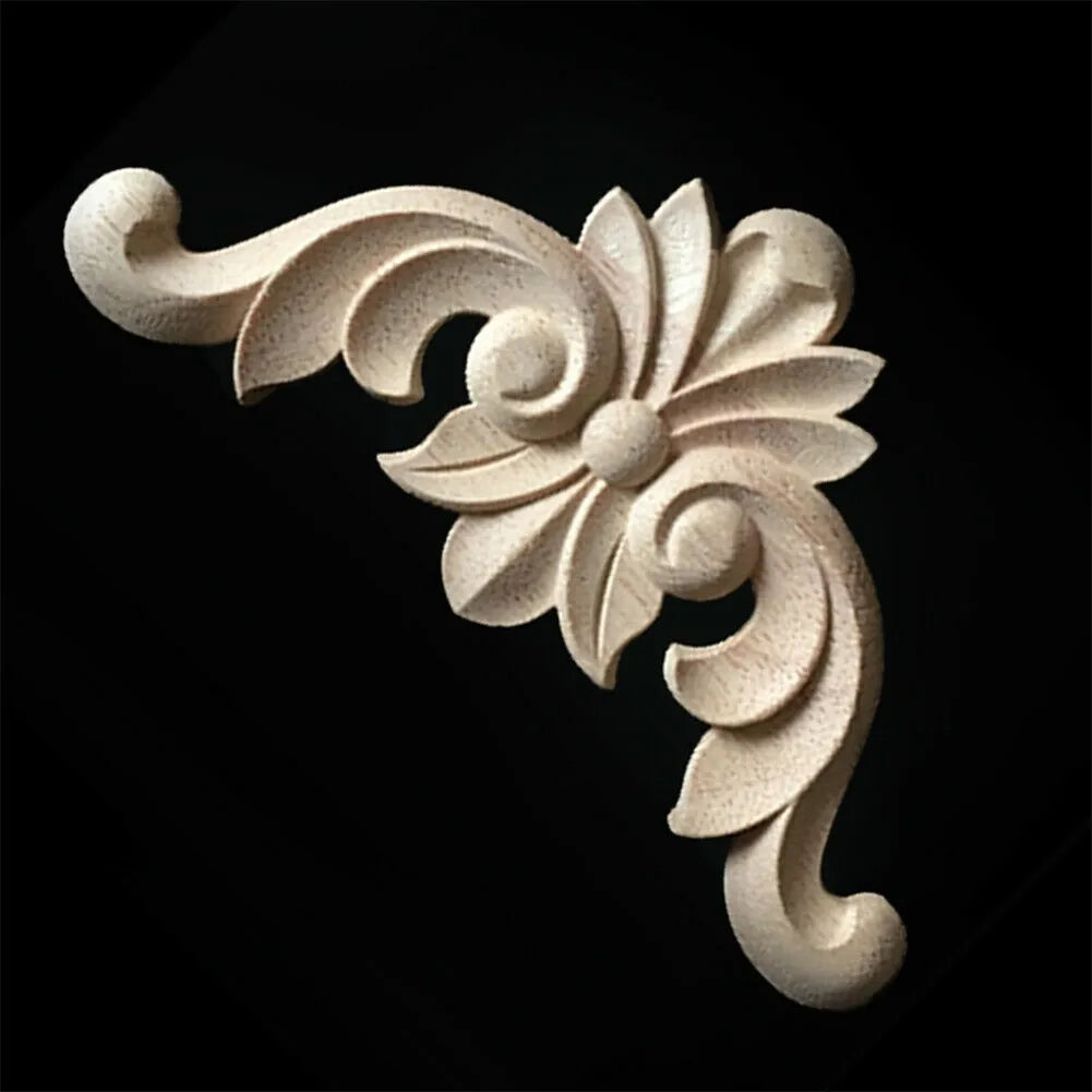 A set of four light-colored wooden carved corner appliques used for furniture and frame decoration.