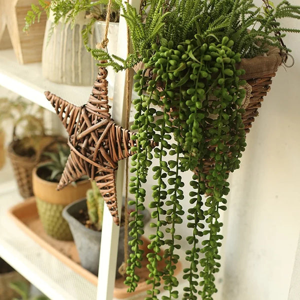 A hanging artificial succulent bonsai plant with green foliage and brown stems displayed on a white shelf.