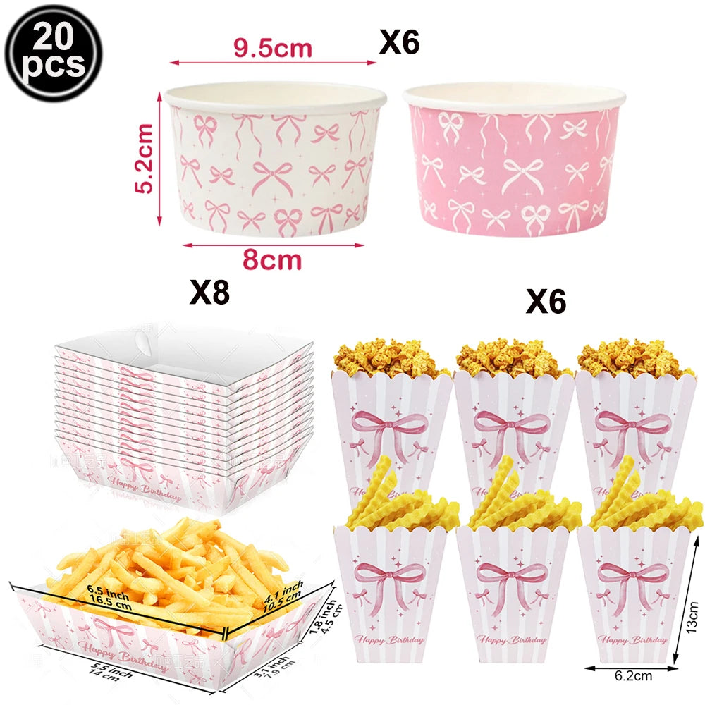 A set of pink bow-themed birthday party supplies including cups and potato chips.