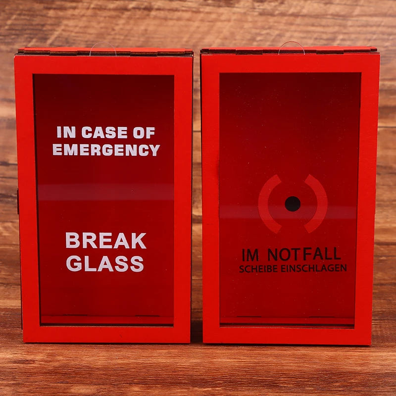 Dos cajas rojas etiquetadas como EN CASO DE EMERGENCIA BREAK GLASS e IM NOTFALL, para romper