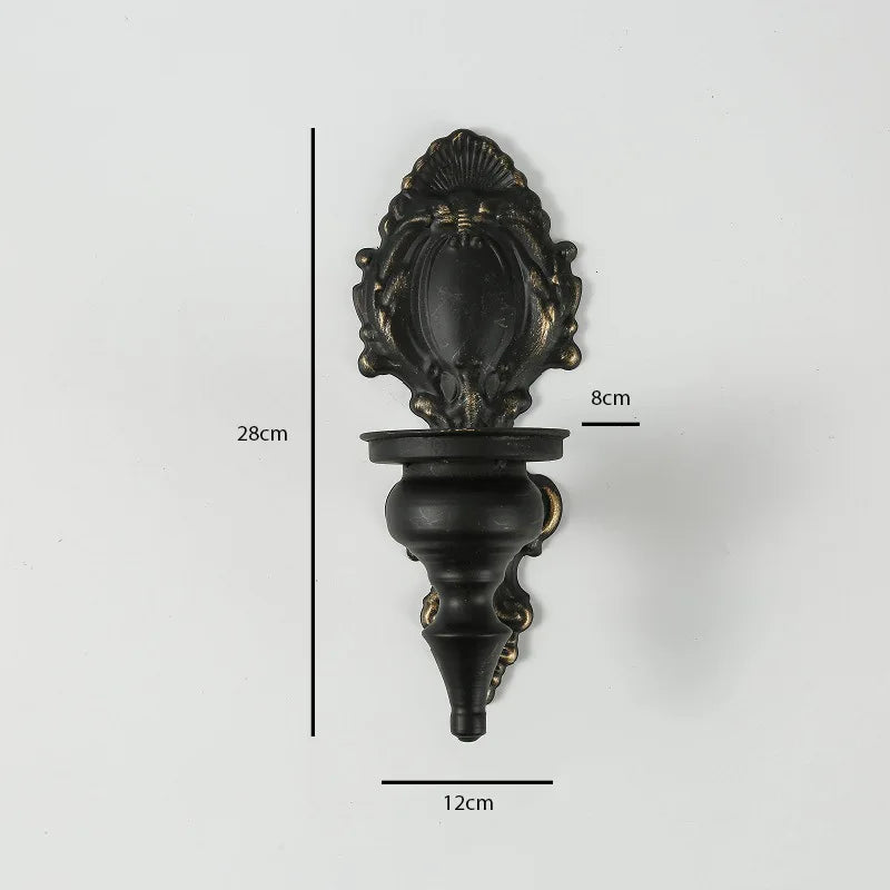 Vintage black wall-mounted double candle holder with an ornate finial and a decorative base.