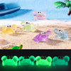 A set of luminous resin mini crab decor figures in various colors resting on a sandy surface.