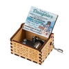 A vintage hand-cranked wooden music box with a lid featuring a message to a daughter