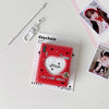 A red heart-shaped keychain featuring a white heart design and a small photo, displayed next to a silver chain.