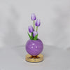 A purple glass vase holds three purple tulips, serving as a LED night light.