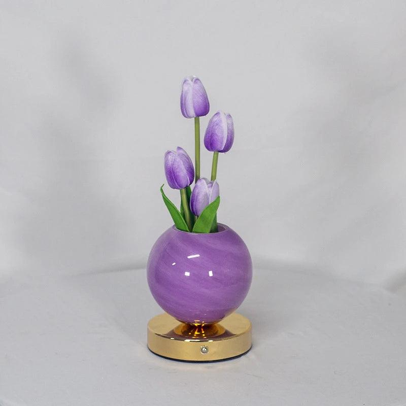A purple glass vase holds three purple tulips, serving as a LED night light.