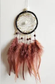 A feather pendant charm featuring a round mirror suspended from a dark cord.