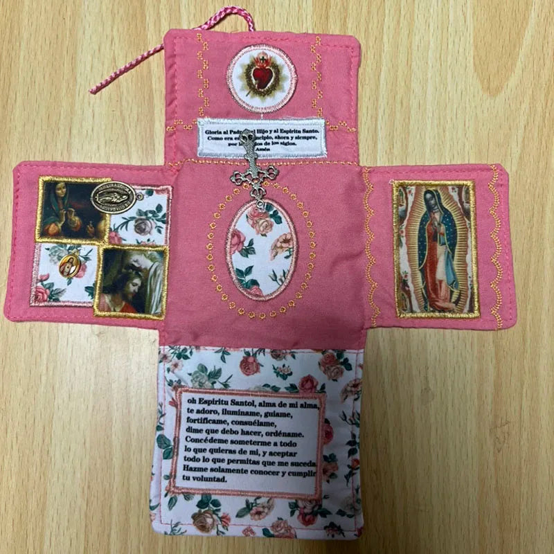 Handcrafted pink fabric pocket shrine with a cross and religious imagery