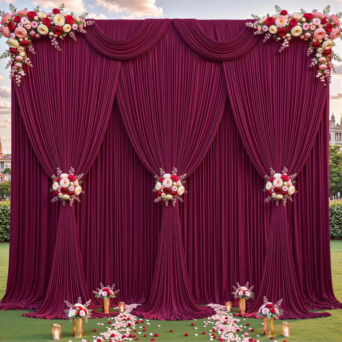 A deep magenta fabric backdrop with draped curtains and floral accents for an event setting.