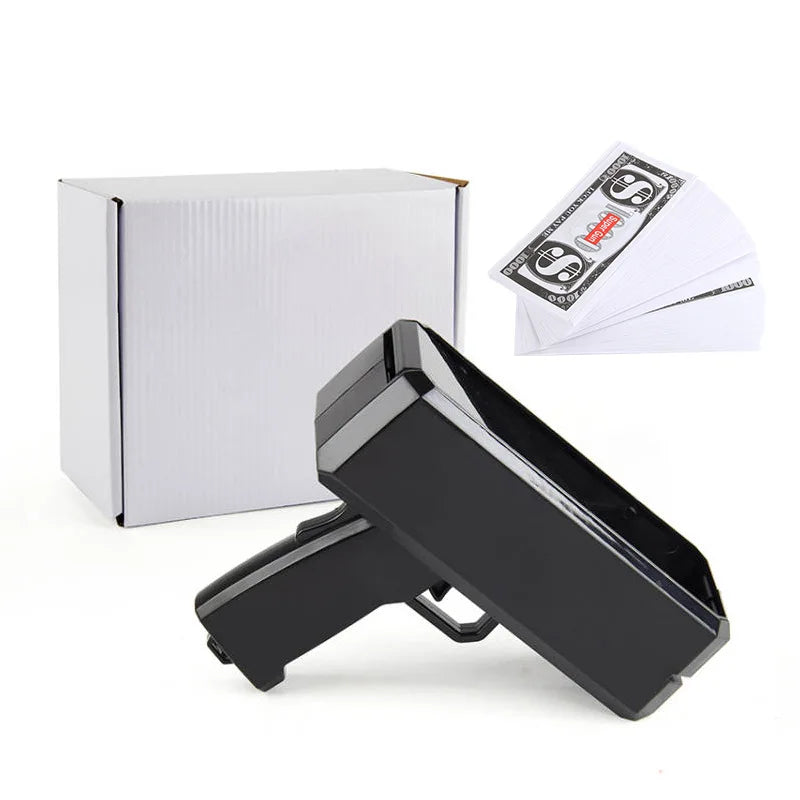 A black money shooter toy gun is shown next to its packaging and some fake dollar bills.