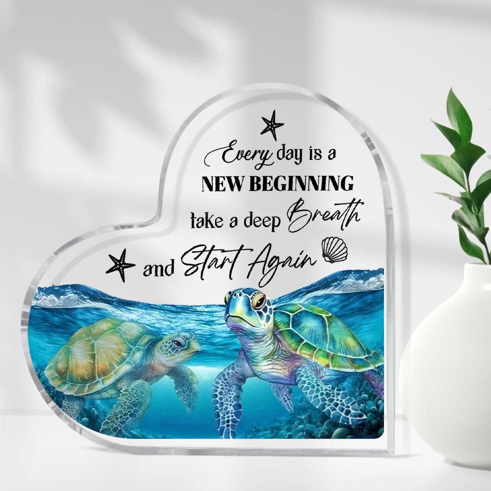 Clear acrylic heart-shaped sign featuring a blue sea turtle illustration and inspirational text