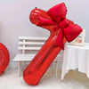 A large red foil number balloon shaped like the number 1, featuring a matching red bow, displayed on a white table.