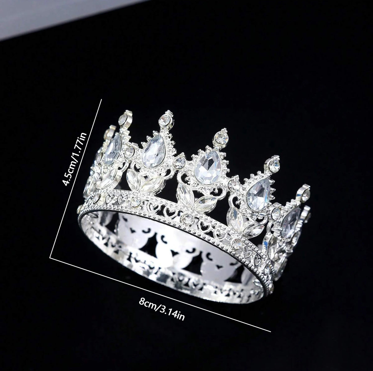 A silver crystal rhinestone crown ring shown against a black background.