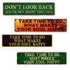 A set of four vintage metal signs with inspirational phrases on green and orange backgrounds.