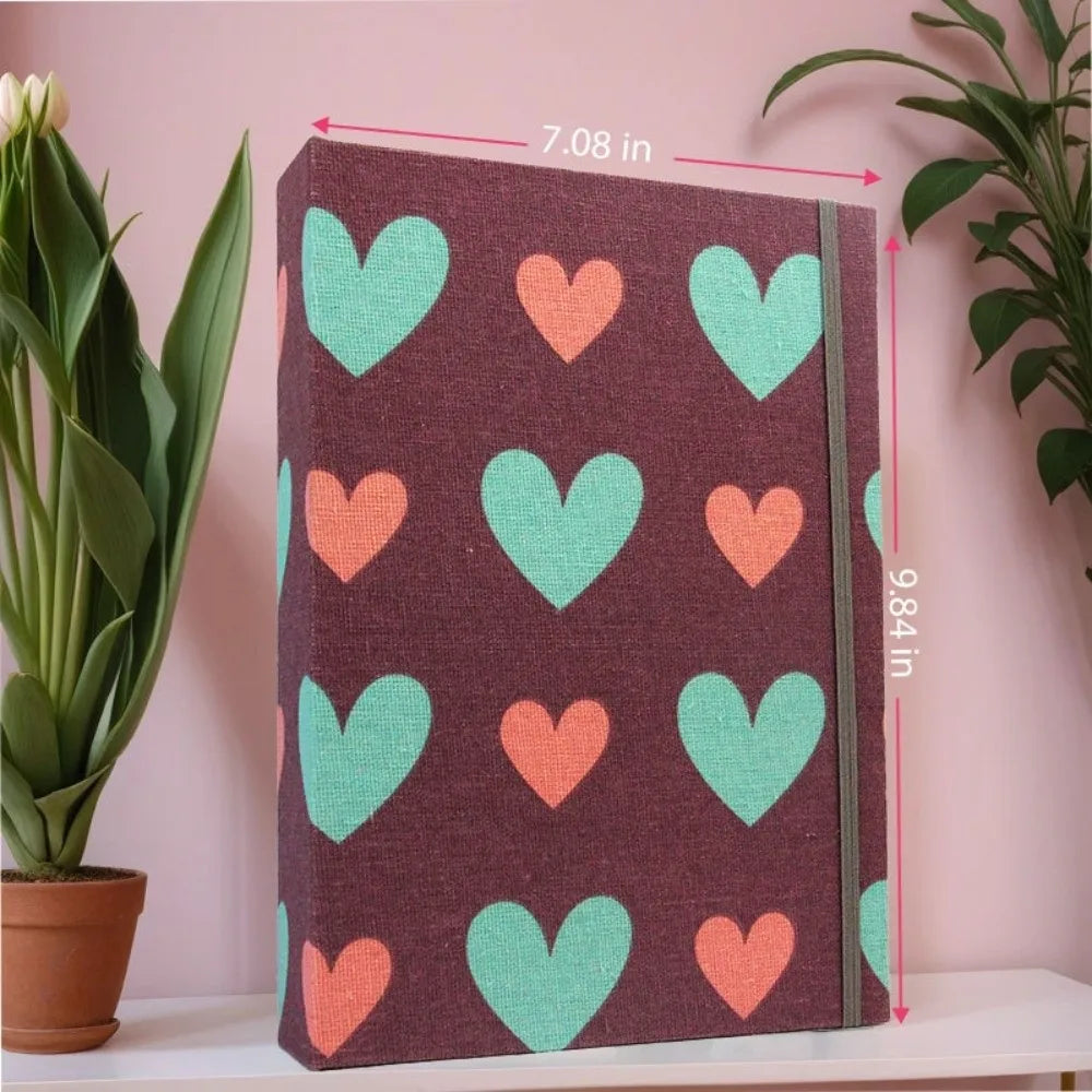 Álbum de recortes de tela morada oscura decorado con corazones repetidos de verde claro y naranja.