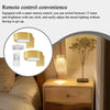 A bedside table lamp with a round light and a remote control shown next to a potted plant.