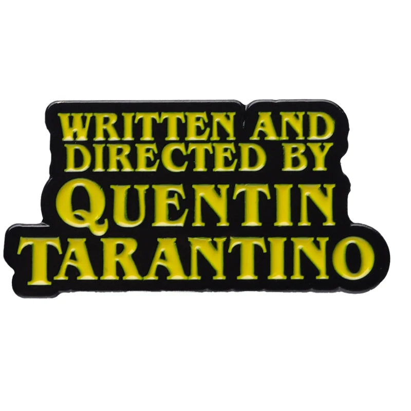 Black enamel pin with yellow text that reads Written and Directed by Quentin Tarantino