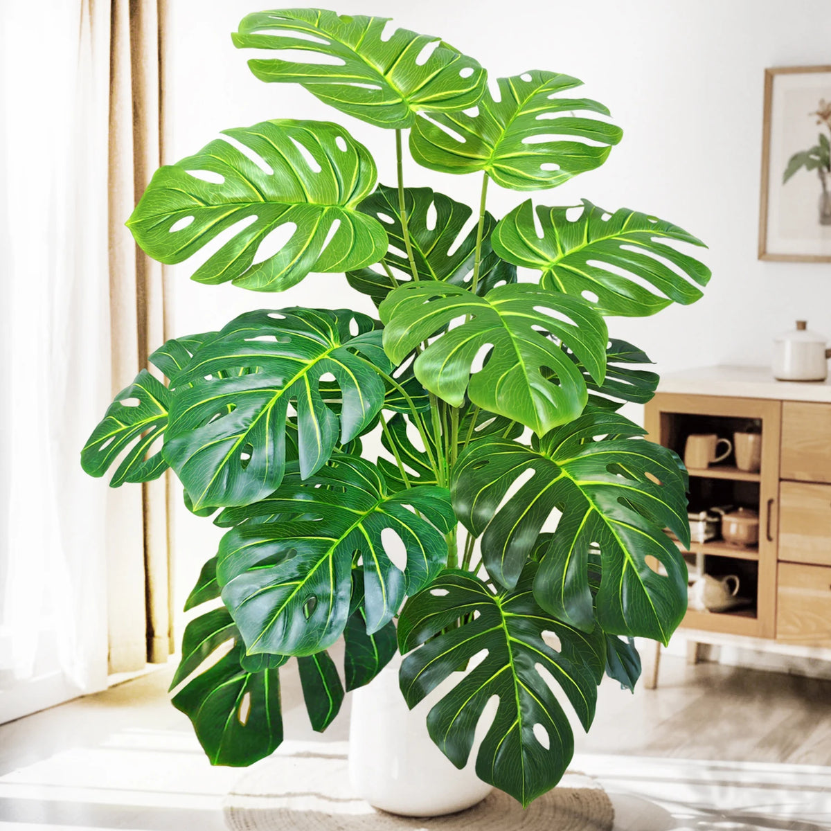 A vibrant artificial monstera plant with large green silk leaves displayed indoors.