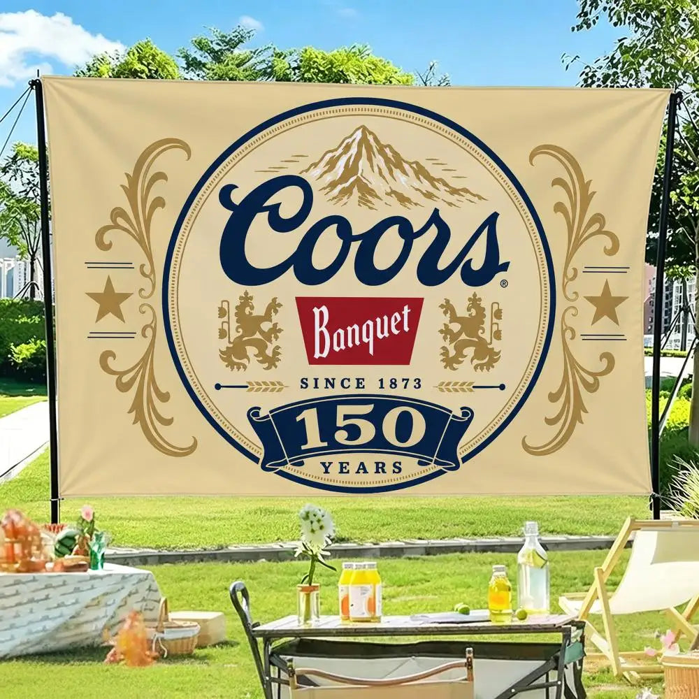 A beige flag banner featuring the text Coors Banquet since 1873 and 150 years, set outdoors on a grassy lawn.