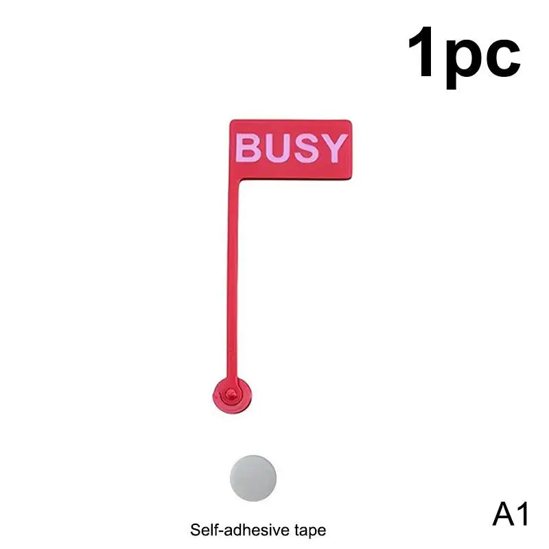 A red desk sign with the word BUSY and a mounting mechanism, packaged with self-adhesive tape.