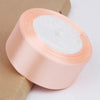 Rolls of pink satin ribbon used for crafts, gift wrapping, and DIY projects