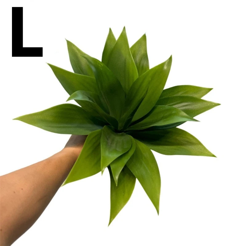 A hand holds a vibrant green artificial agave plant with spiky leaves.
