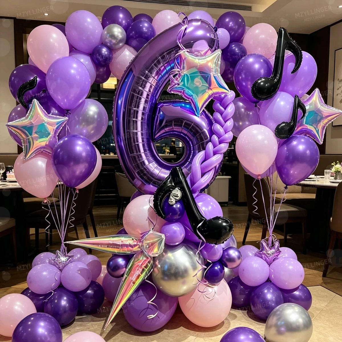 A purple and silver balloon column set decorated with musical notes and stars for a birthday theme.