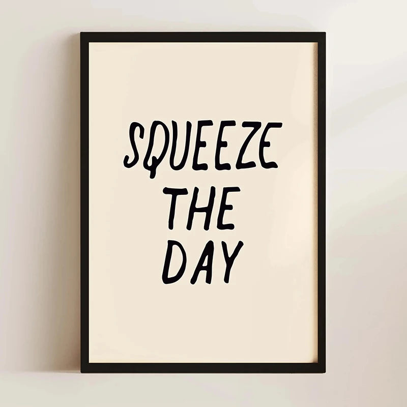 A framed canvas print with black text that reads SQUEEZE THE DAY on a light beige background.