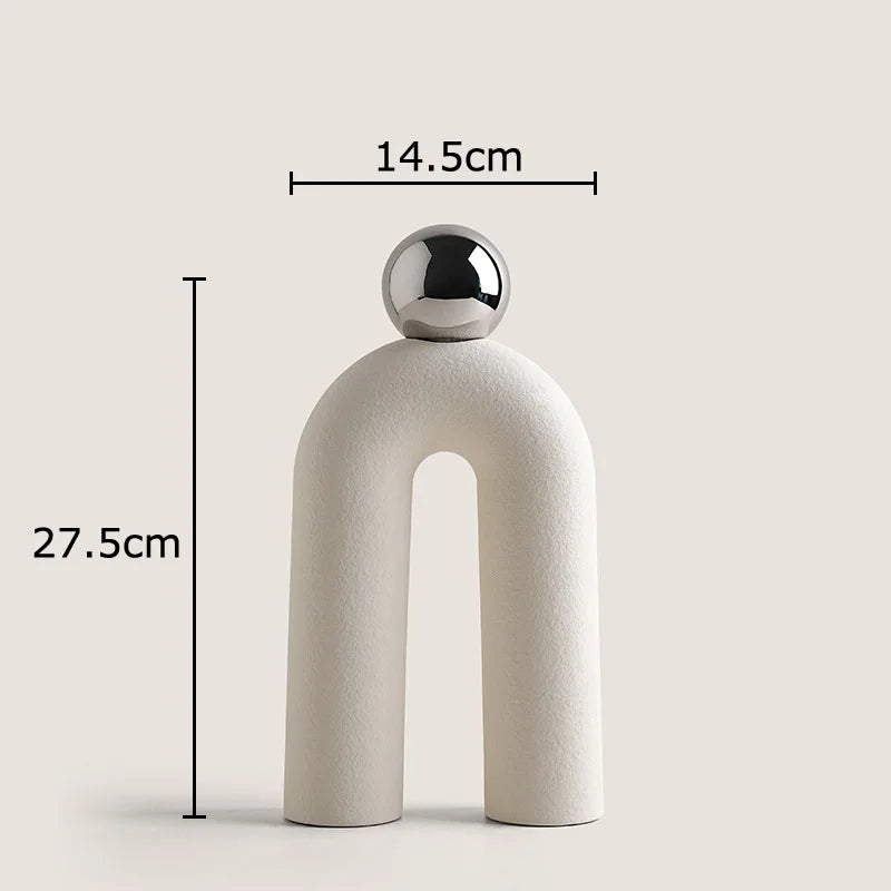 A beige ceramic U-shaped tabletop vase with a silver spherical top, shown against a light background.