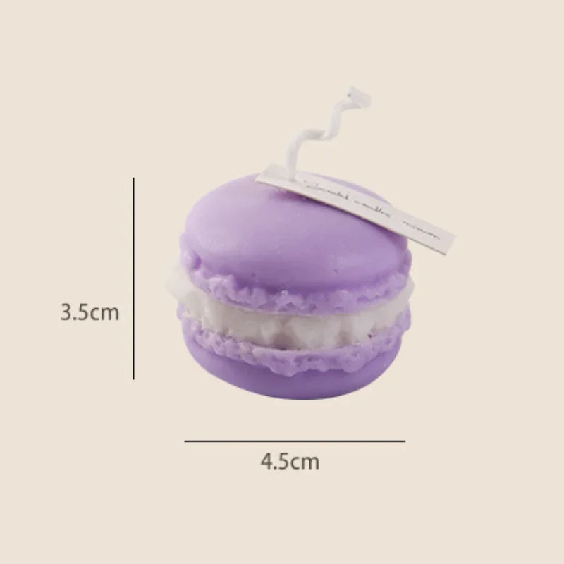 A purple macaron-shaped candle with white filling and a white tag.