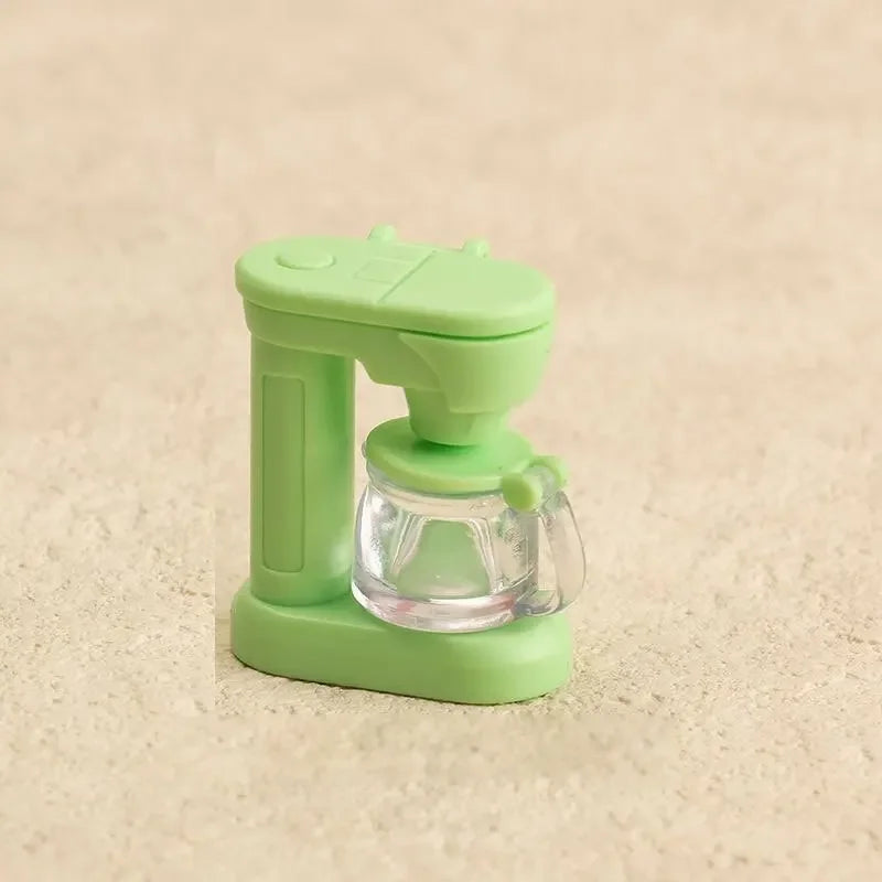 A light green kitchen appliance dollhouse accessory featuring a clear glass component and a plastic handle.