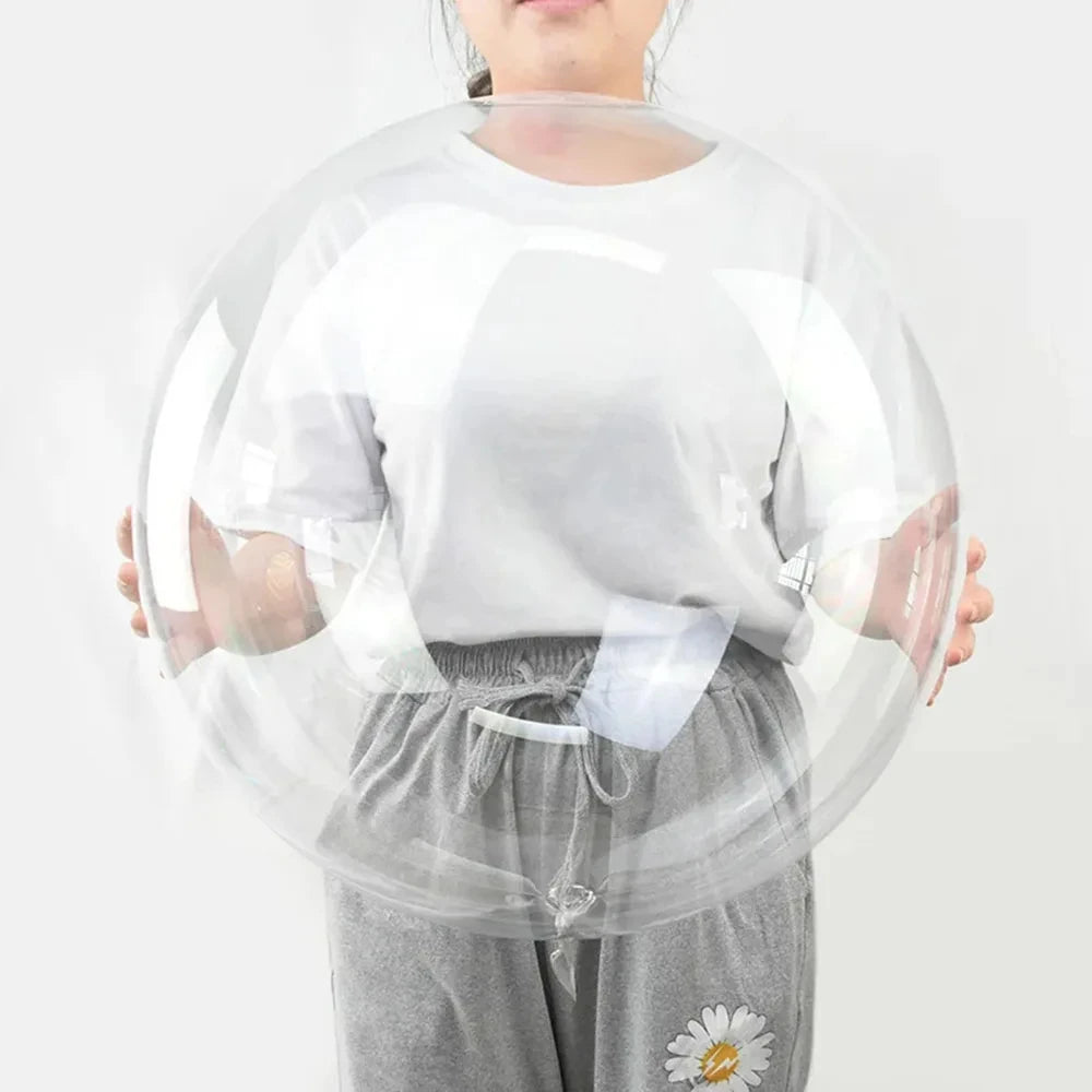 A person is holding a large, transparent inflatable balloon that is shaped like a bobo.