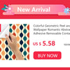 A close-up of colorful geometric peel and stick wallpaper being applied to a surface.