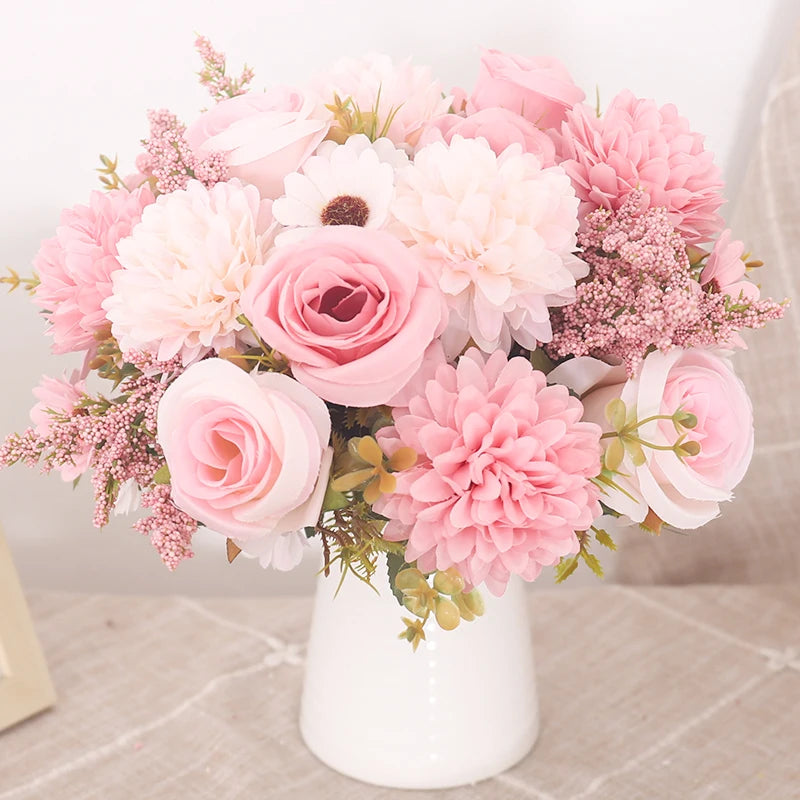 A bouquet of pink and peach silk roses and hydrangeas arranged in a white vase.
