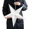 A person holds an elegant white hollow star pendant light decor with gold star cutouts against a dark coat.