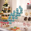 A tiered acrylic display rack holding numerous colorful cupcakes and desserts for an event.